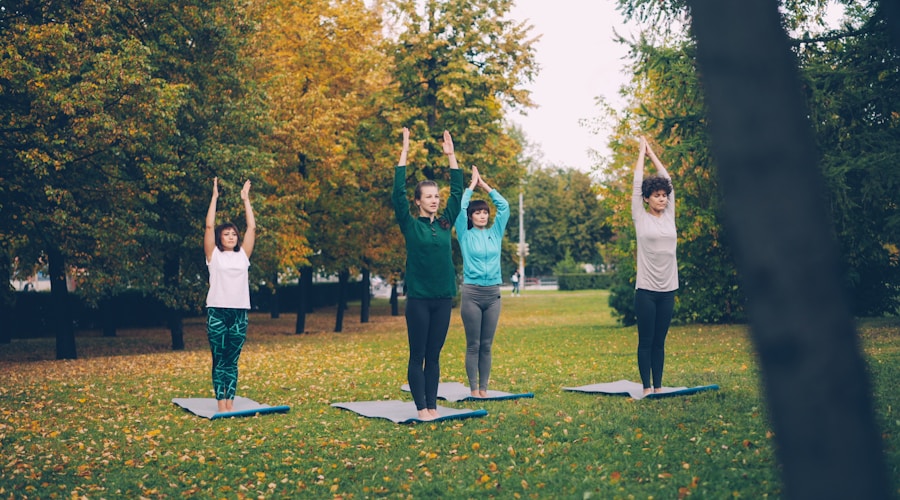 Group of people doing yoga peacefully in a park during autumn