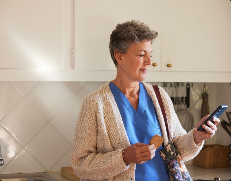 Woman checking the LifeLyne.fit app in her kitchen